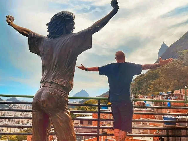 A person posing next to the Michael Jackson statue in Favela Santa Marta.